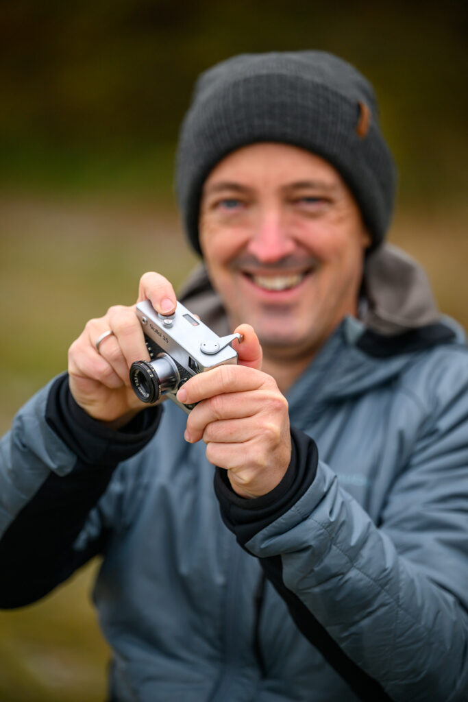 Rollei 35 in den Händen eines Benutzers, der Film wird mit der linken Hand weitertransportiert.