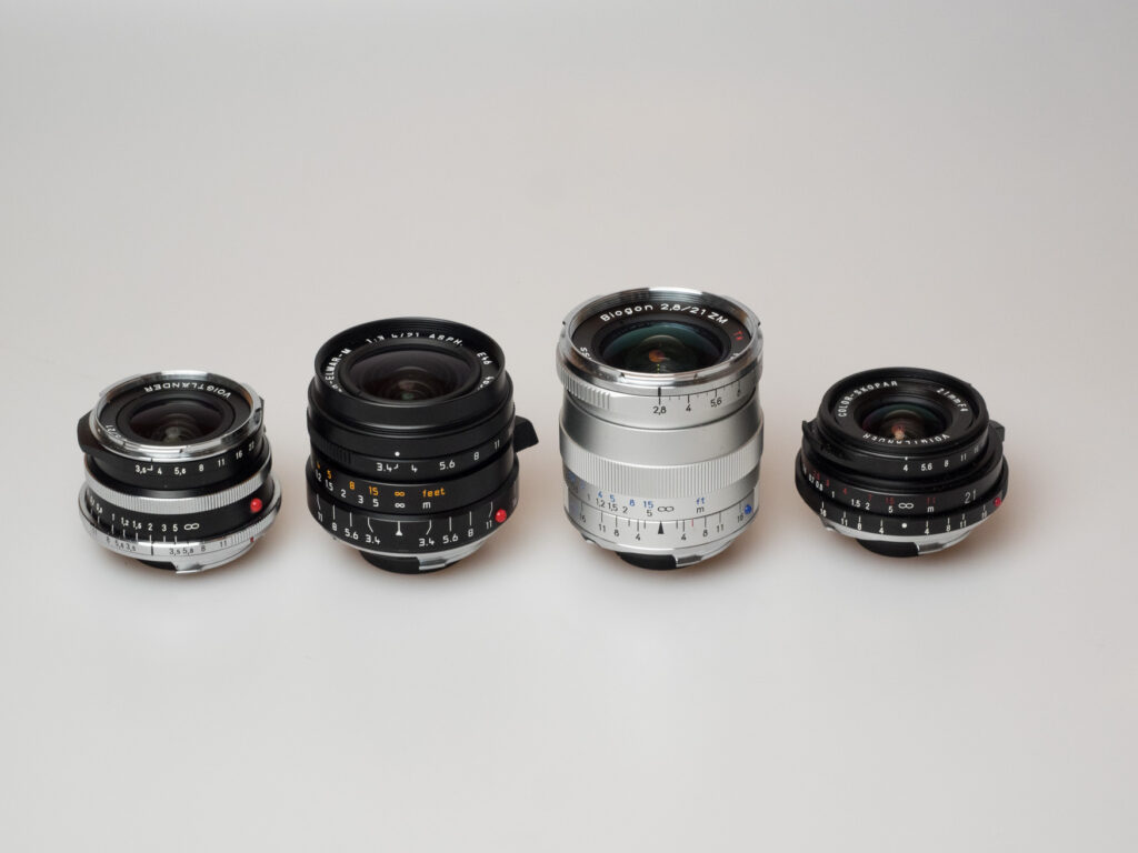 Produktbild zeigt Voigtländer Color-Skopar 3,5/21 VM mit weiteren Objektiven mit 21 mm Brennweite von Leica, Zeiss, Voigtländer