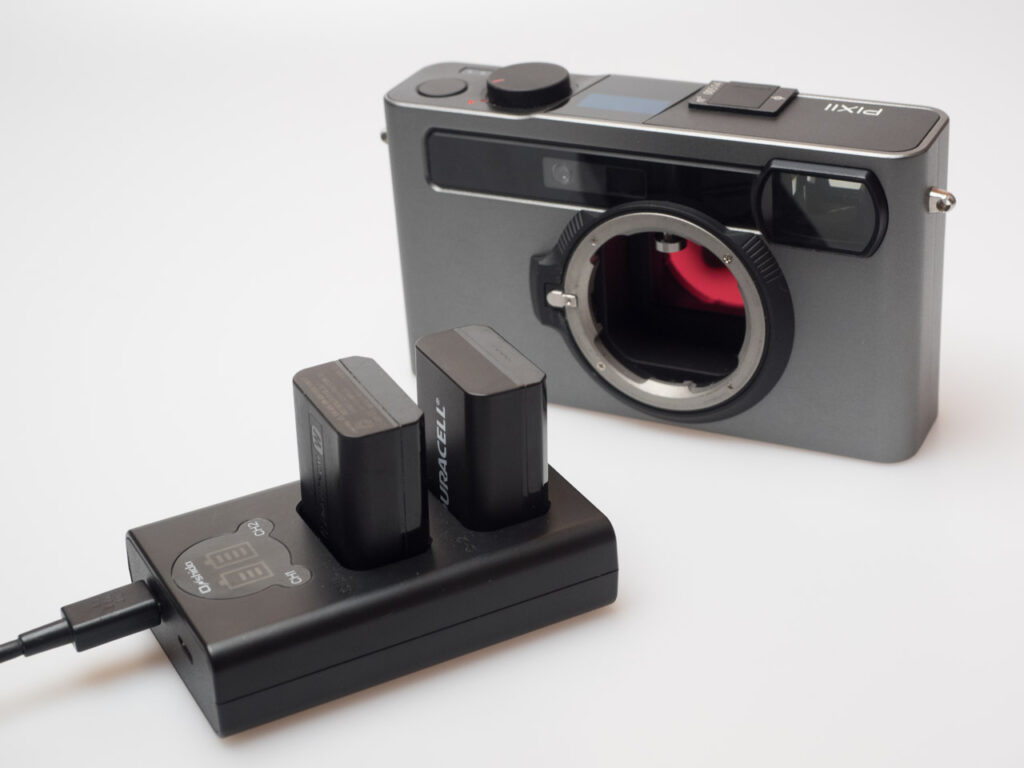 Produktbild zeigt Pixii Messsucherkamera (Modell A2572) mit Batterien und Ladegerät