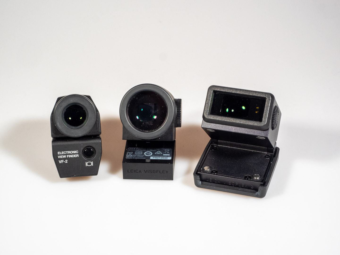 Produktbild zeigt elektronische Sucher von Leica bzw. deren Entsprechungen: Olympus VF-2 (=Leica EVF2), Visoflex 020, Visoflex 2