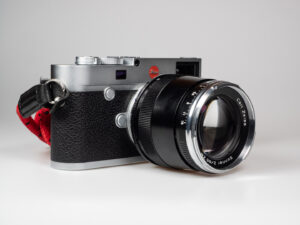 Produktbild zeigt Zeiss Sonnar 2/85 ZM an Leica M10 digitaler Messsucherkamera