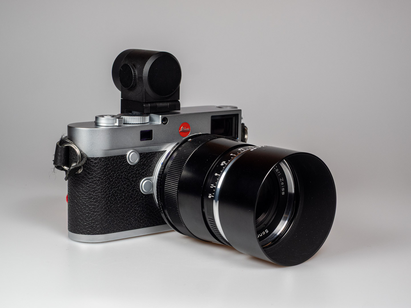 Produktbild zeigt Zeiss Sonnar 2/85 ZM an Leica M10 digitaler Messsucherkamera, hier mit elektronischem Sucher Visoflex.