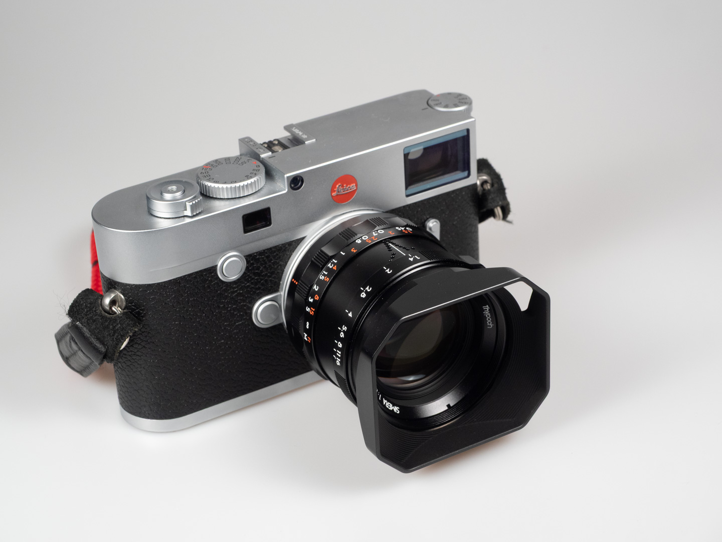 Produktfoto von Thypoch Simera 1.4/50: montiert an einer silbernen Leica-M-Messsucherkamera, von oben mit Blick auf die Deckkappe fotografiert.